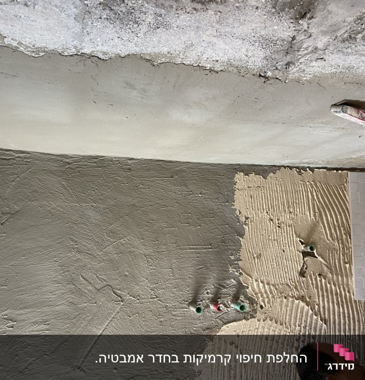 קיר בטון עם אריחים בתהליך הדבקה ושכבת טיח